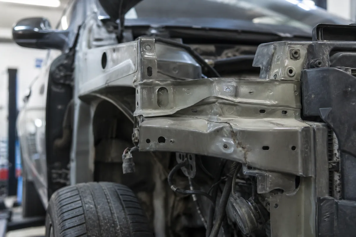 Longeron avant d’un véhicule accidenté vu en atelier, capot déposé