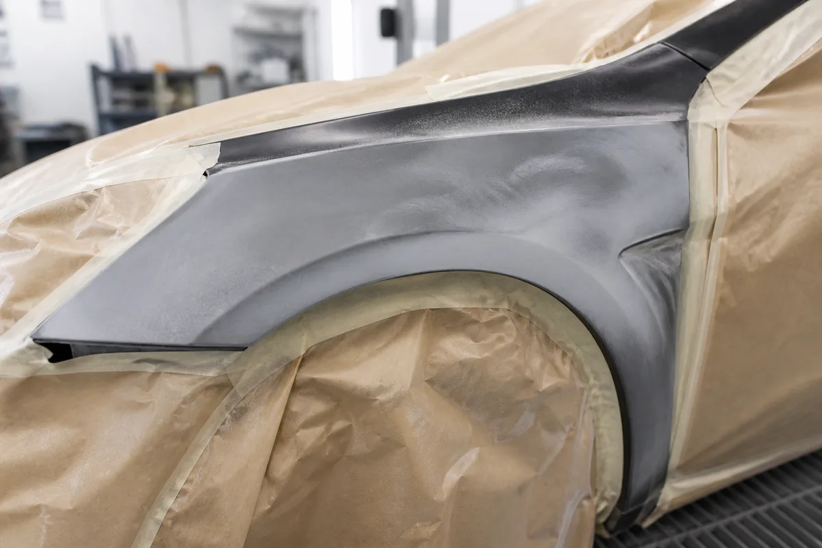 Élément de carrosserie masqué et poncé dans une zone de préparation avant peinture